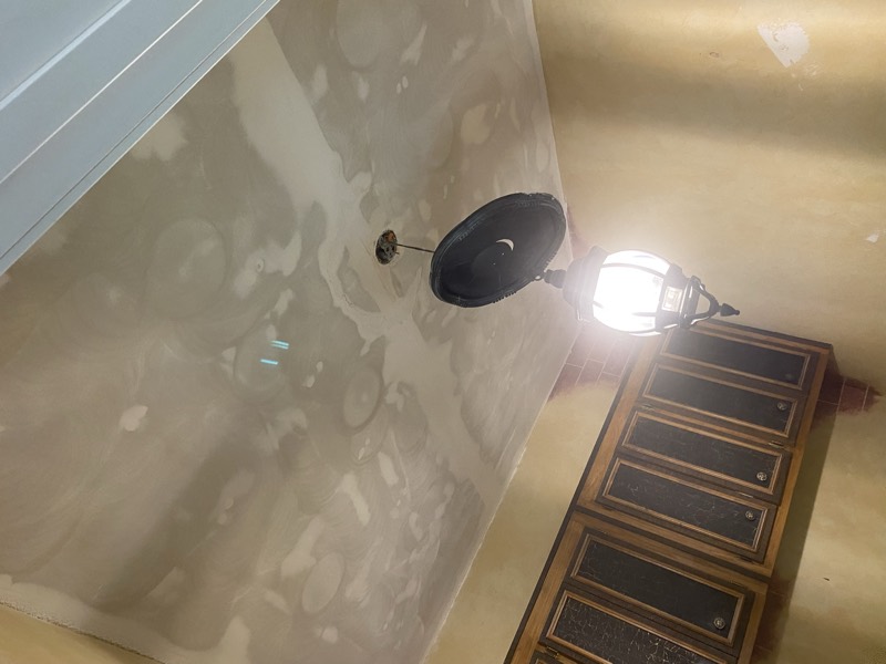 Ceiling being skim-coated smooth near kitchen cabinets