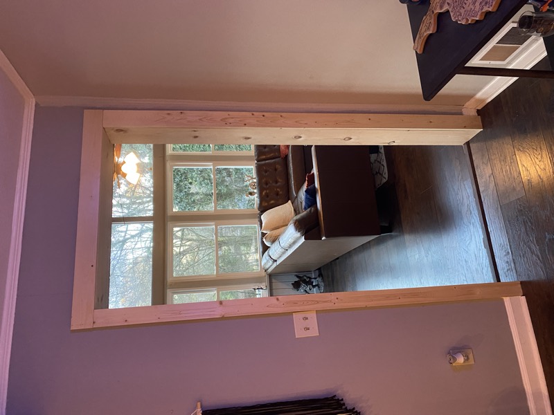 The finished wall opening, trimmed and painted, between two rooms