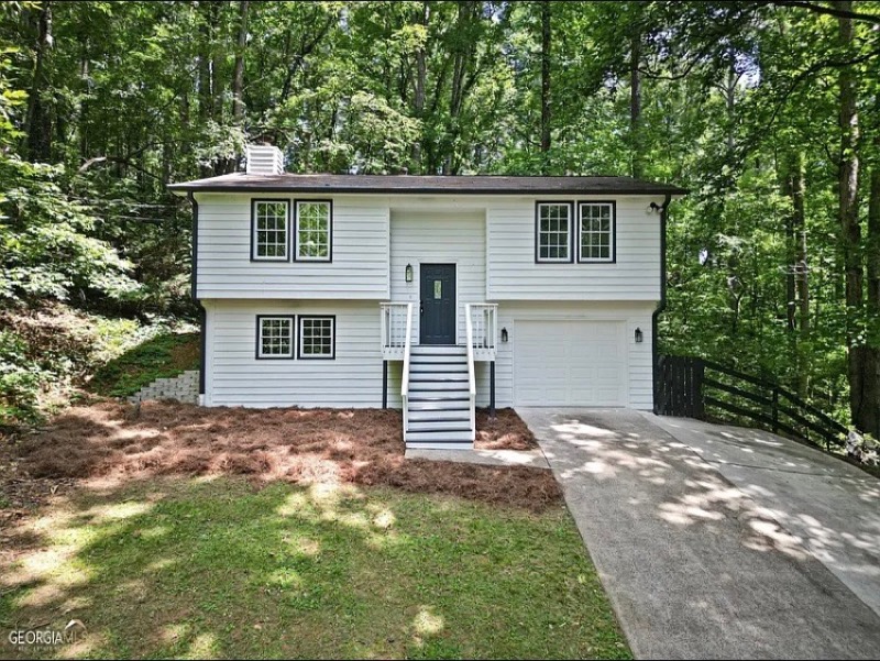 The same home after renovation with white siding and black trim