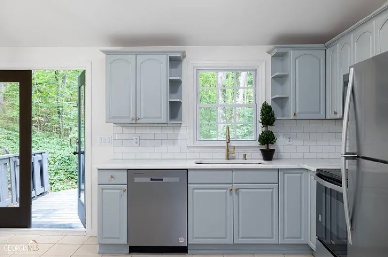 The same kitchen refreshed with painted cabinets and a subway-tile backsplash