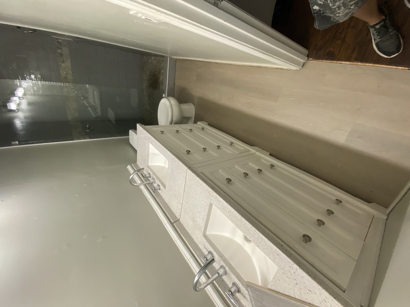 Finished bathroom with a white vanity, quartz counters, and a tiled walk-in shower
