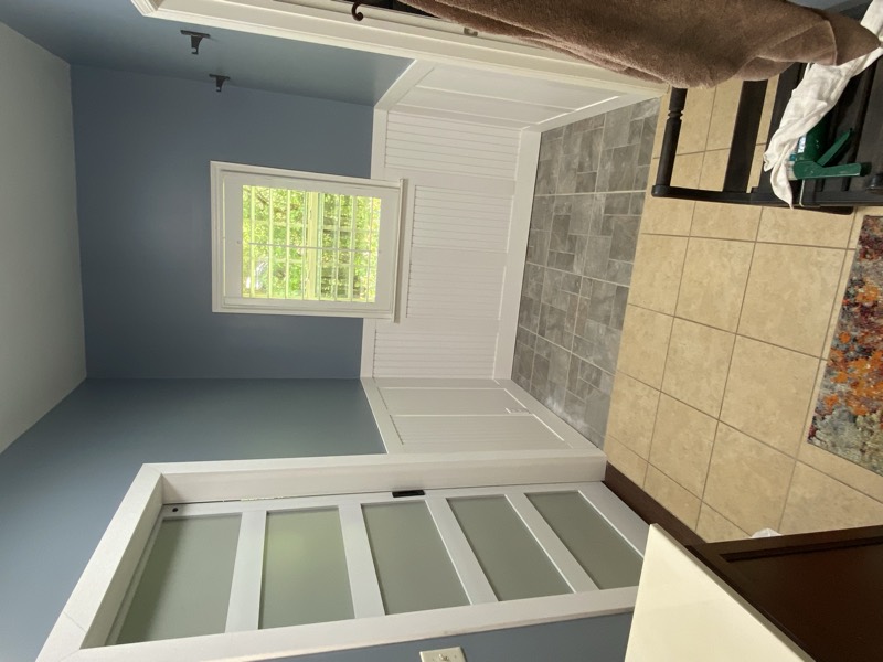 Finished bathroom with a sliding barn door, board-and-batten wainscoting, and tile floor