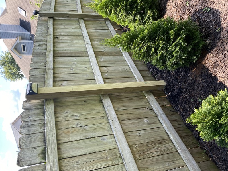 The rebuilt fence with a new post and fresh landscaping