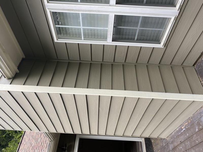 The repaired and repainted green lap siding