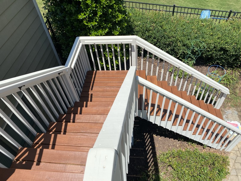 Deck stairs with white railings and freshly stained treads