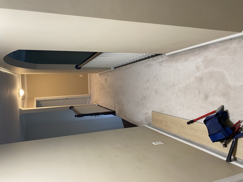 Hallway during a flooring replacement with a new plank and tools laid out