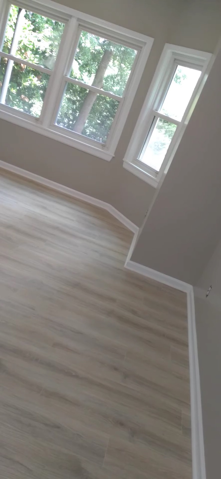 Walkthrough of a finished room with new flooring and trim